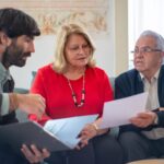 Senior couple consulting with a professional advisor, discussing documents indoors.
